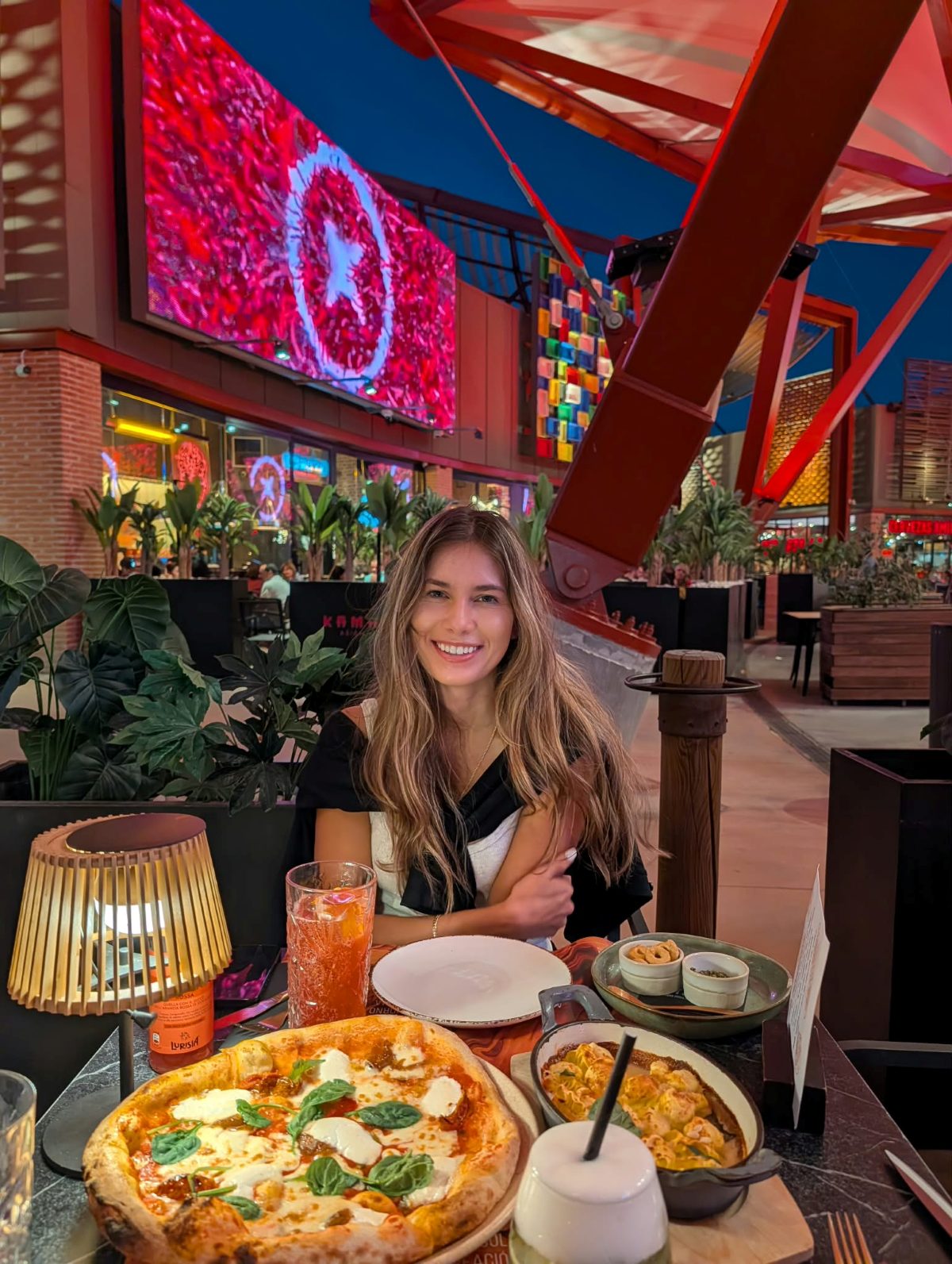 Dinner outdoors with pizza and pasta on the table