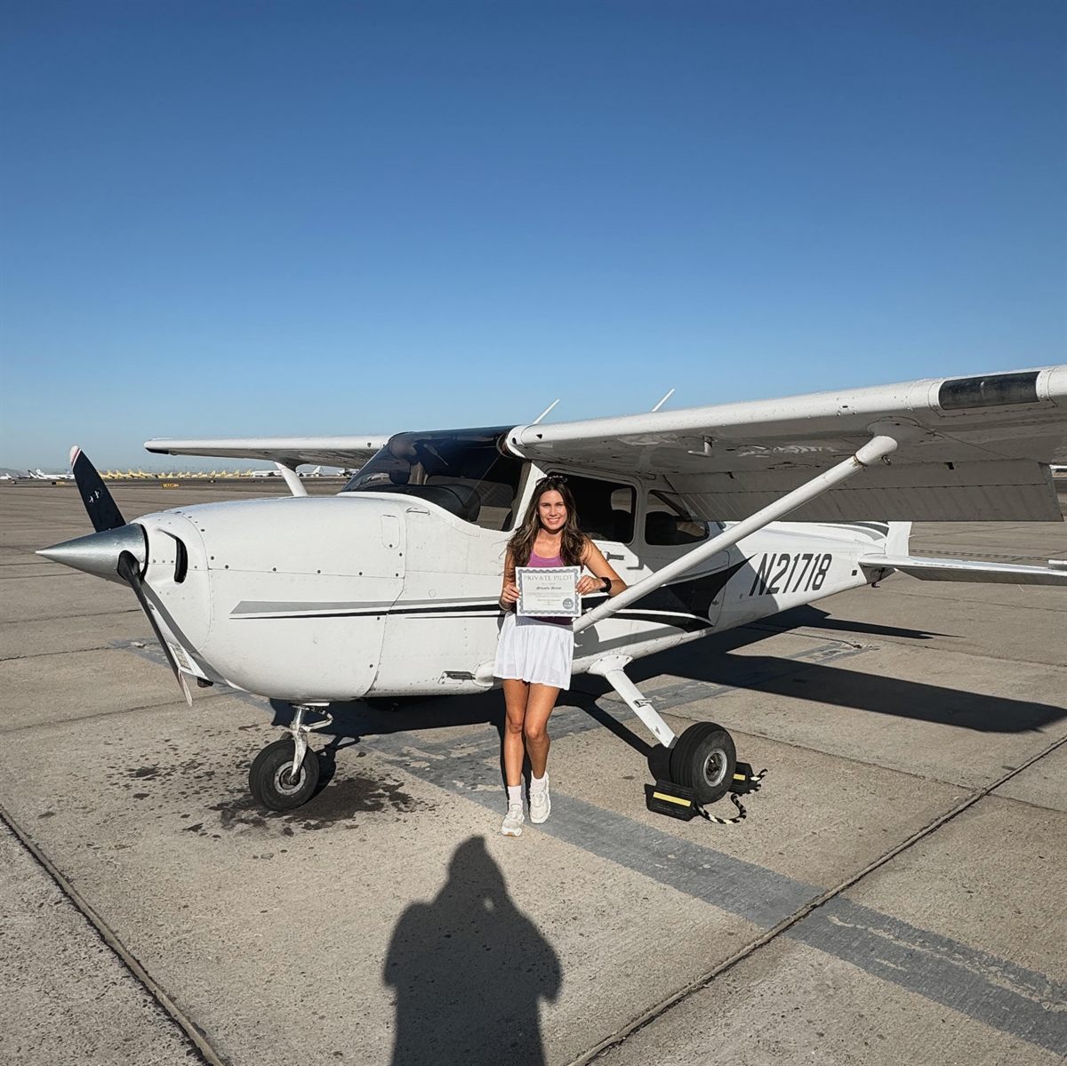 Holding my private pilot certificate beside a Cessna 172